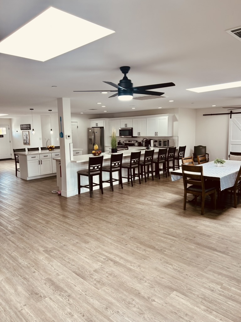 Resident bedroom with black iron bed frame, white bedding, and natural light
