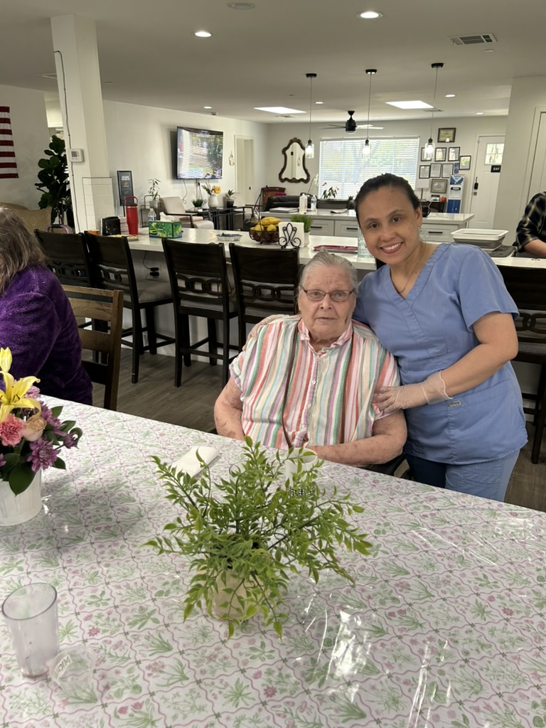 A caregiver sharing a warm moment with a resident at Encompass