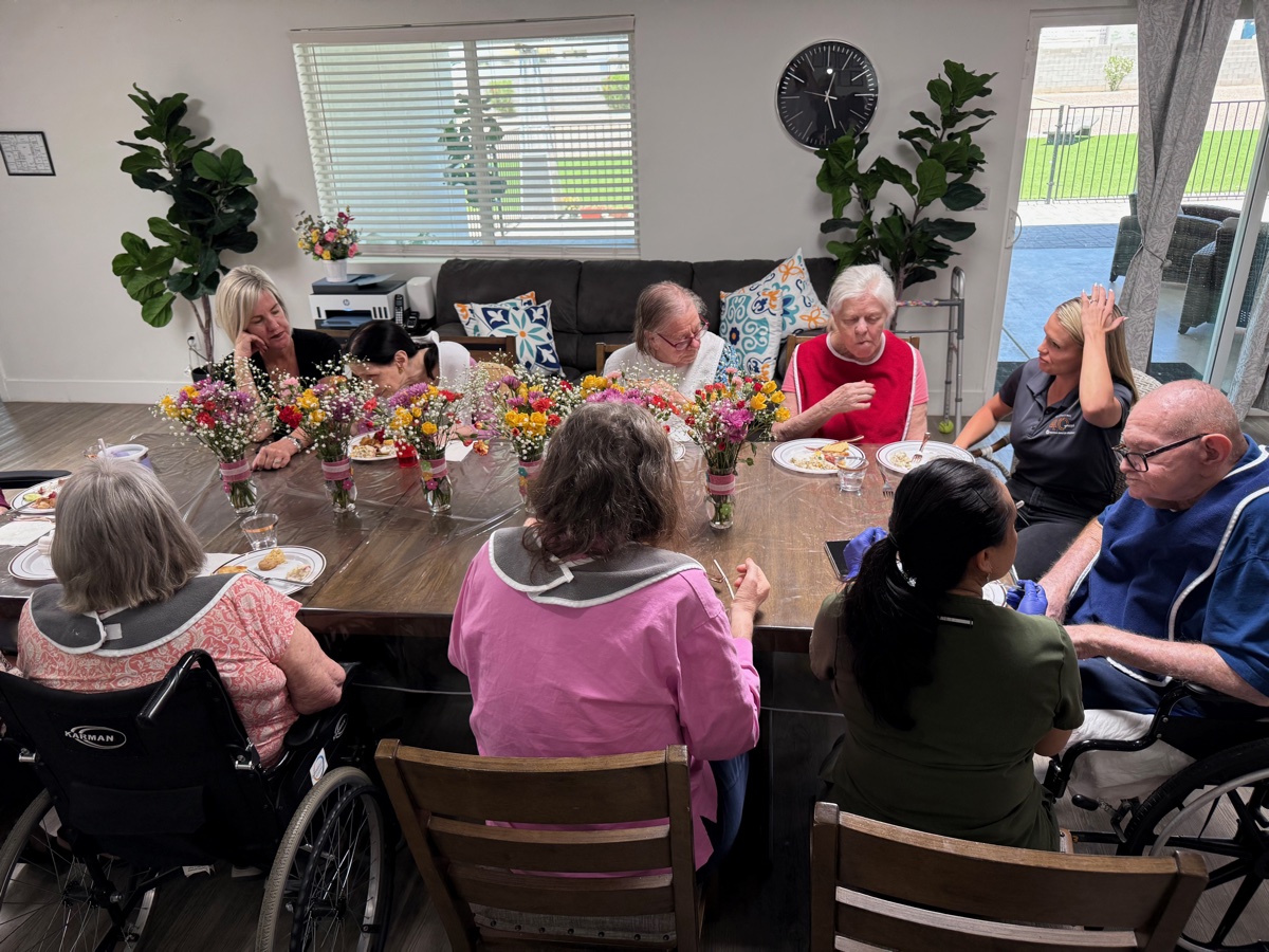 Wide view of the living and dining area filled with residents and family enjoying Mother's Day lunch